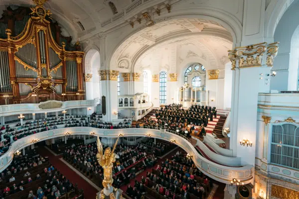 Un groupe de personnes dans un grand bâtiment blanc.