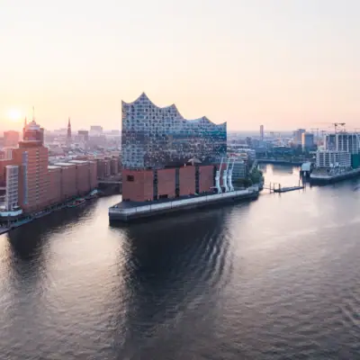 Ville avec un fleuve et des bâtiments ; au premier plan, un bateau sur l'eau.