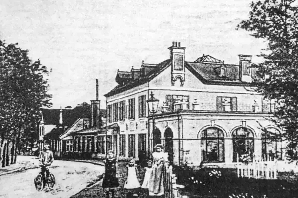 Schwarz-weiß Bild des Hotels Louis C. Jacob  zwischen 1922 und 1955. Vor dem Hotel steht eine Frau in einem langen hellen Kleid zusammen mit 3 Kindern. Ein Mann fährt auf einem Fahrrad auf der Straße.