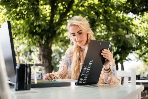 Une femme est assise à une table et lit un menu.