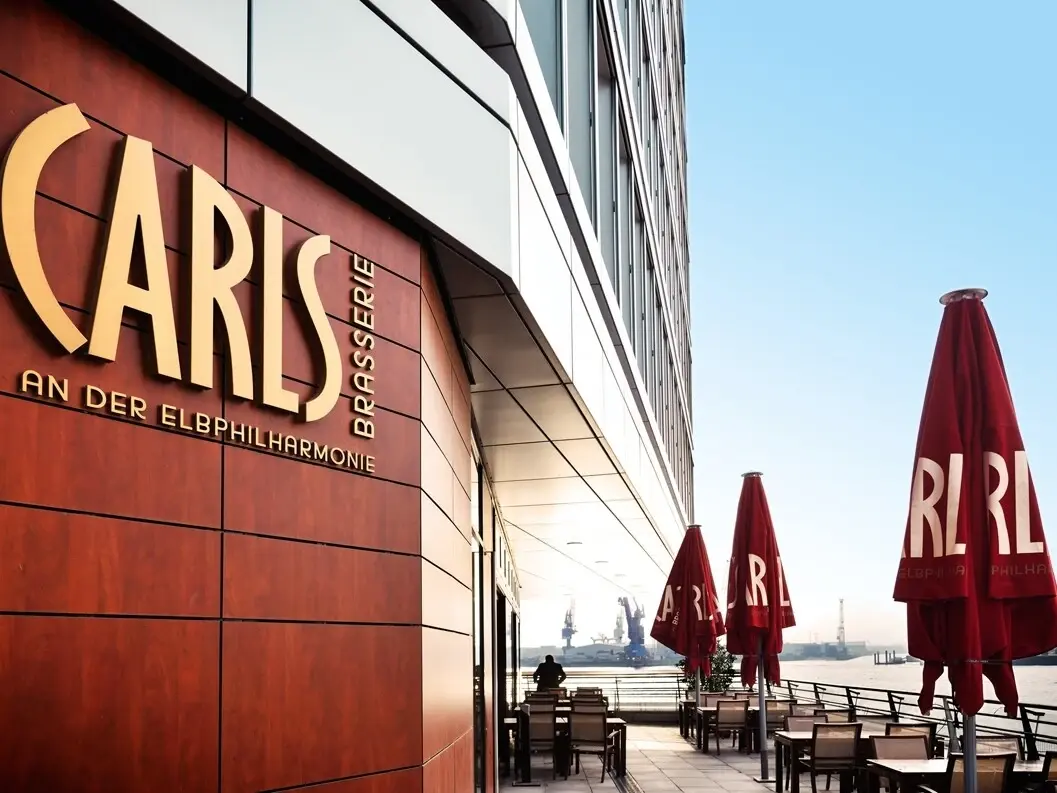 Das CARLS Restaurant an der Elbphilharmonie mit Tischen und Stühlen im Freien.