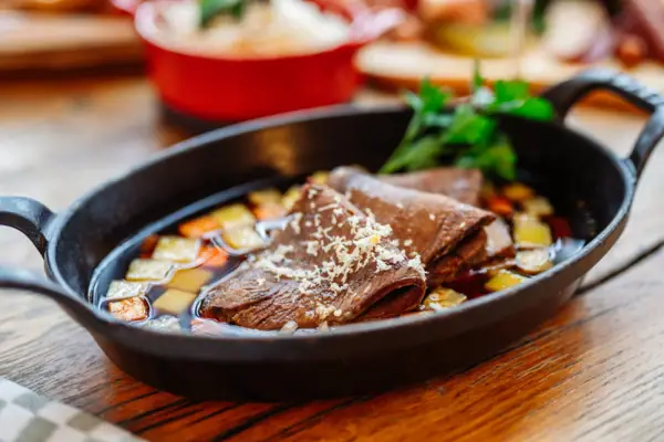 Eine gusseiserne Pfanne mit gekochtem Rindertafelspitz.