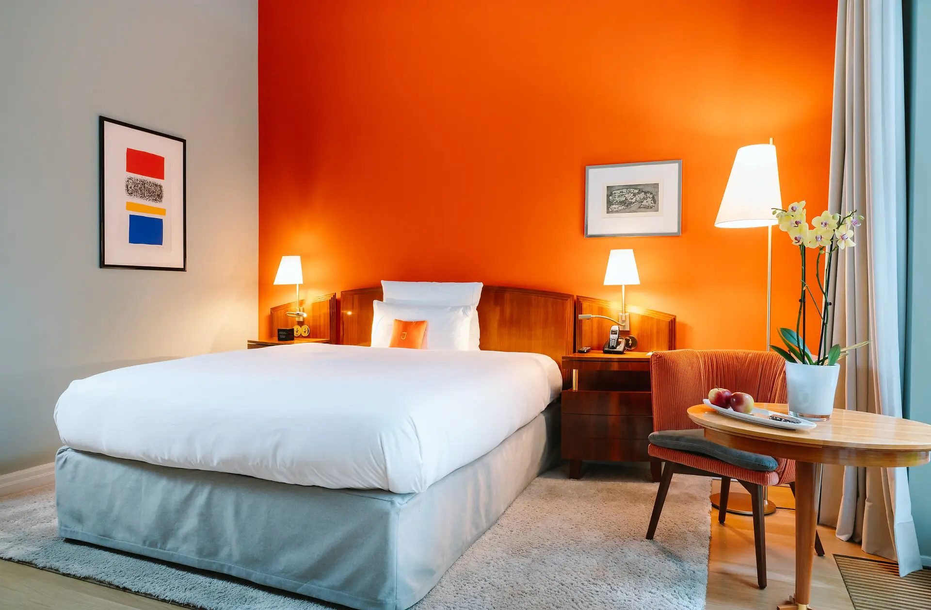 Un lit dans une chambre aux murs orange.