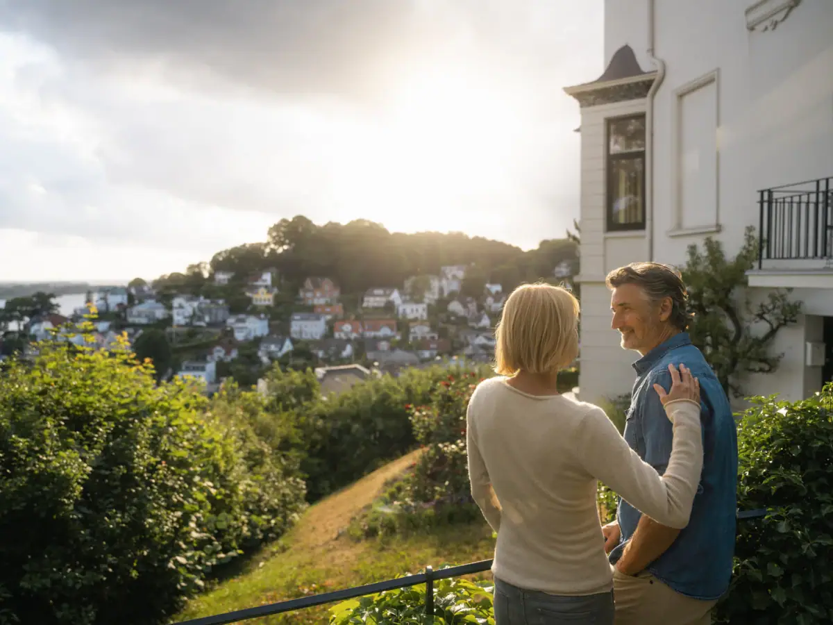 Ein Mann und eine Frau schauen auf das Treppenviertel in Hamburg Blankenese und die Elbe.