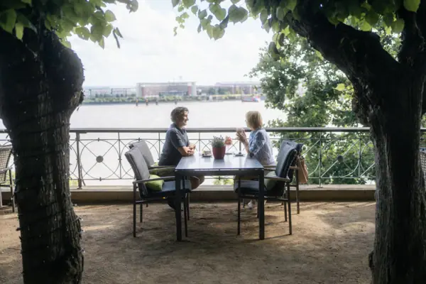 Un homme et une femme sont assis à une table en terrasse.