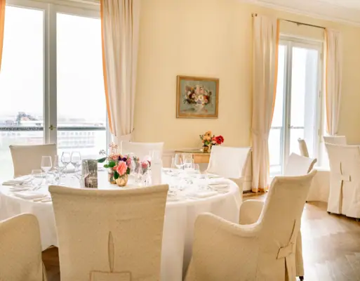 Ein Speiseraum mit einem gedeckten Tisch, Stühlen und einem Blumenarrangement.