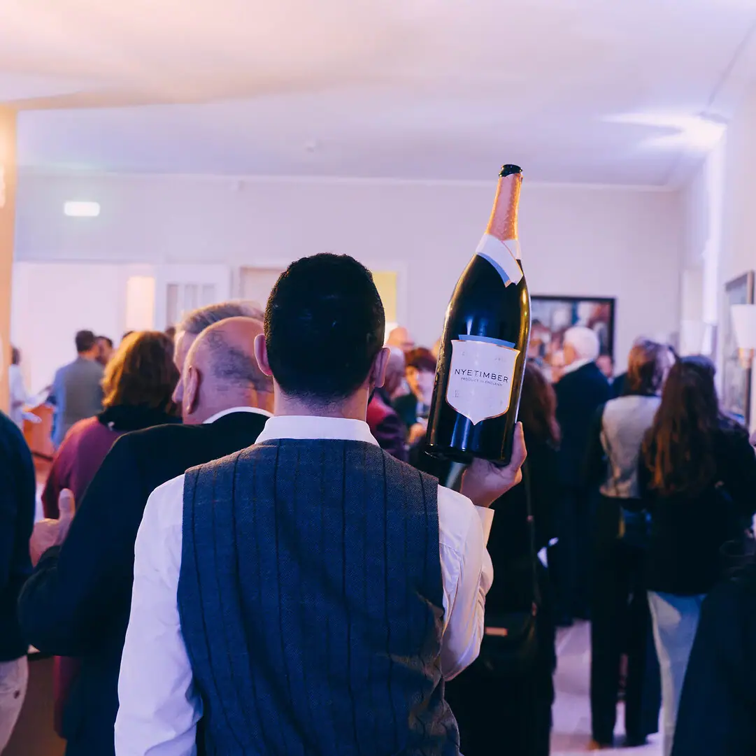 Un homme tient une bouteille de vin.