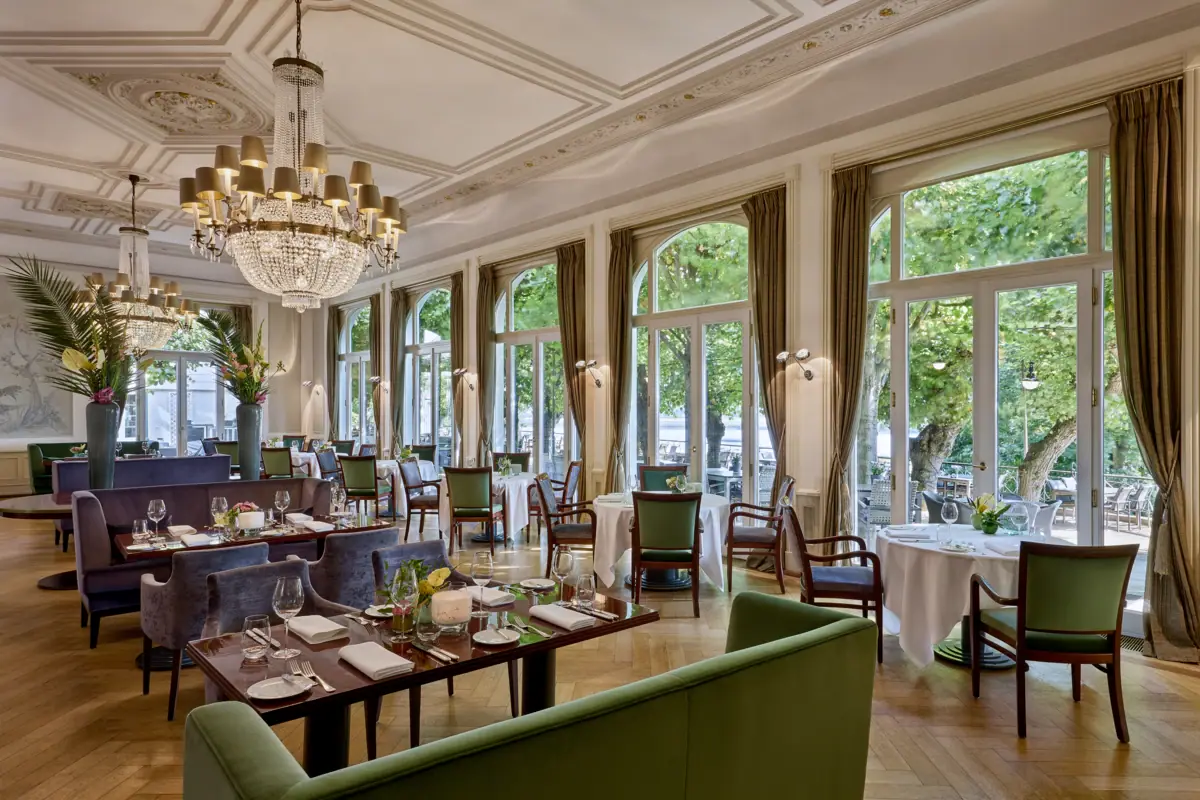 Le restaurant Jacobs Restaurant avec des tables dressées et des lustres.