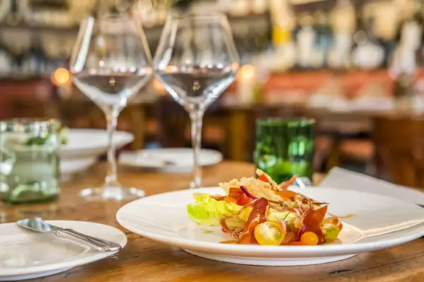 Un plat de nourriture sur une table avec un verre à vin.