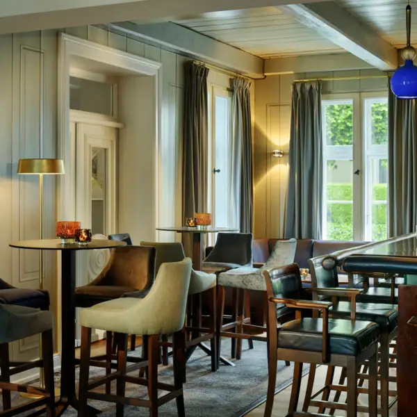 Jacobs Bar Jacobs Bar mkit hohen Tischen und Hockern, sowie einem hölzernen Tresen im Hotel Louis C. Jacob.