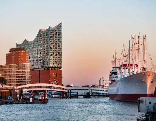 Blick vom Hamburger Hafen aus auf die Elbphilharmonie und ein großes Schiff.