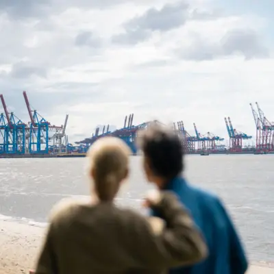 Ein Mann und eine Frau blicken auf die Elbe und den Hafen von Hamburg.