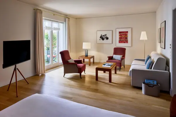 Chambre avec un lit et des canapés, décorée dans un style élégant et moderne.