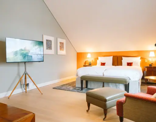 Ein Hotelzimmer mit einem Bett und einem Fernseher.