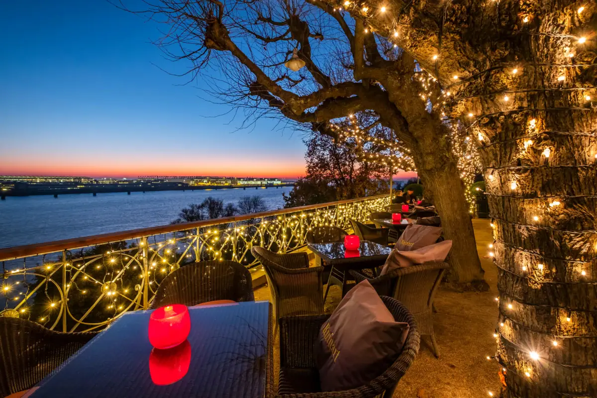 Blick auf die Elbe bei Sonnenuntergang von der festlich geschmückten Lindenterrasse des Hotels Louis C. Jacob aus.