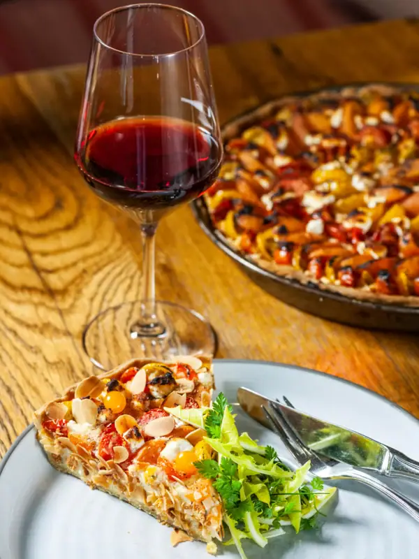 Un verre de vin à côté d'une assiette de nourriture.