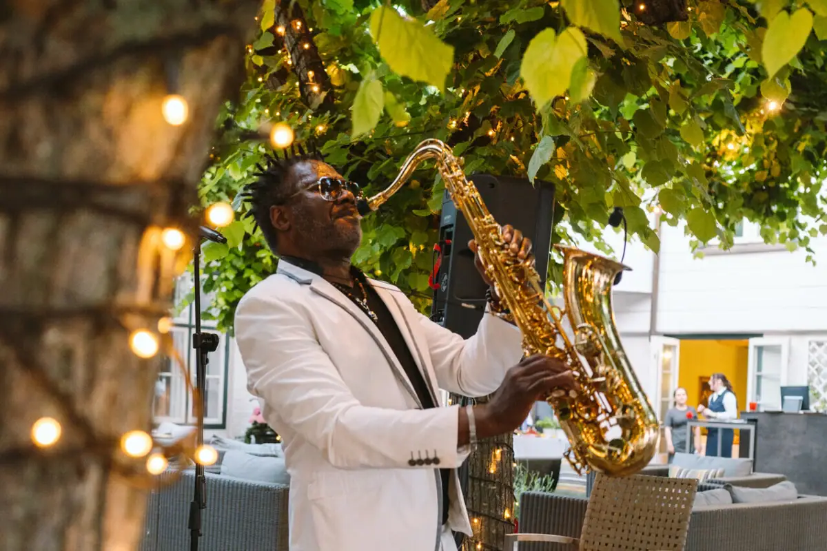 Sommer-Events auf der Lindenterrasse Saxophon-Spieler macht Musik unter Blätterdach der Lindenterrasse.