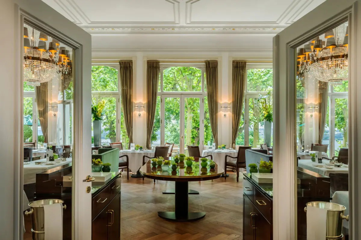 Une pièce avec des tables et des chaises et une grande fenêtre.