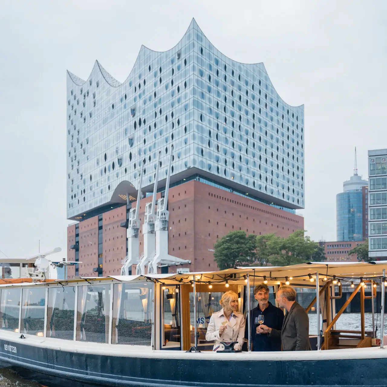 Barkasse MS Jacob  Eine Gruppe von Menschen auf der Barkasse MS Jacob vor der Elbphillharmonie.