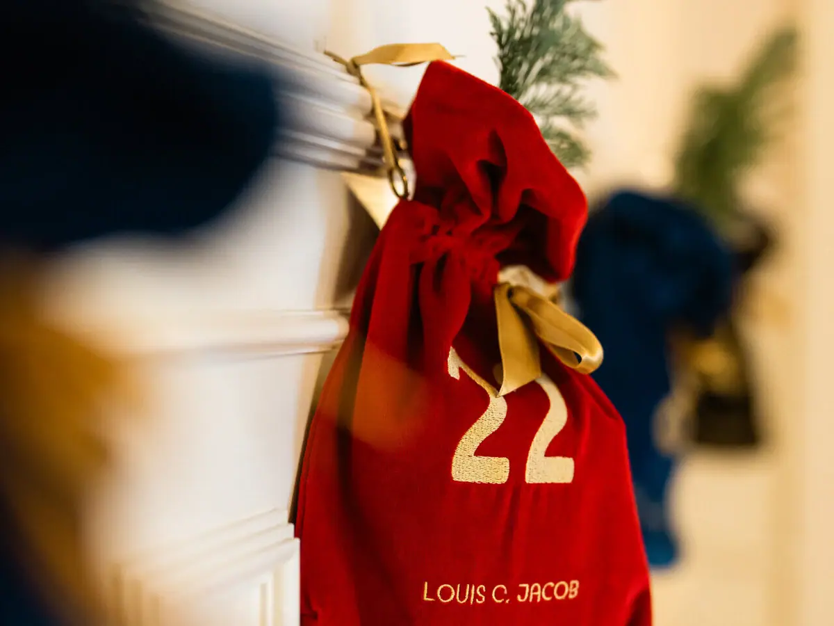 Un sac rouge avec une inscription dorée sur une porte blanche