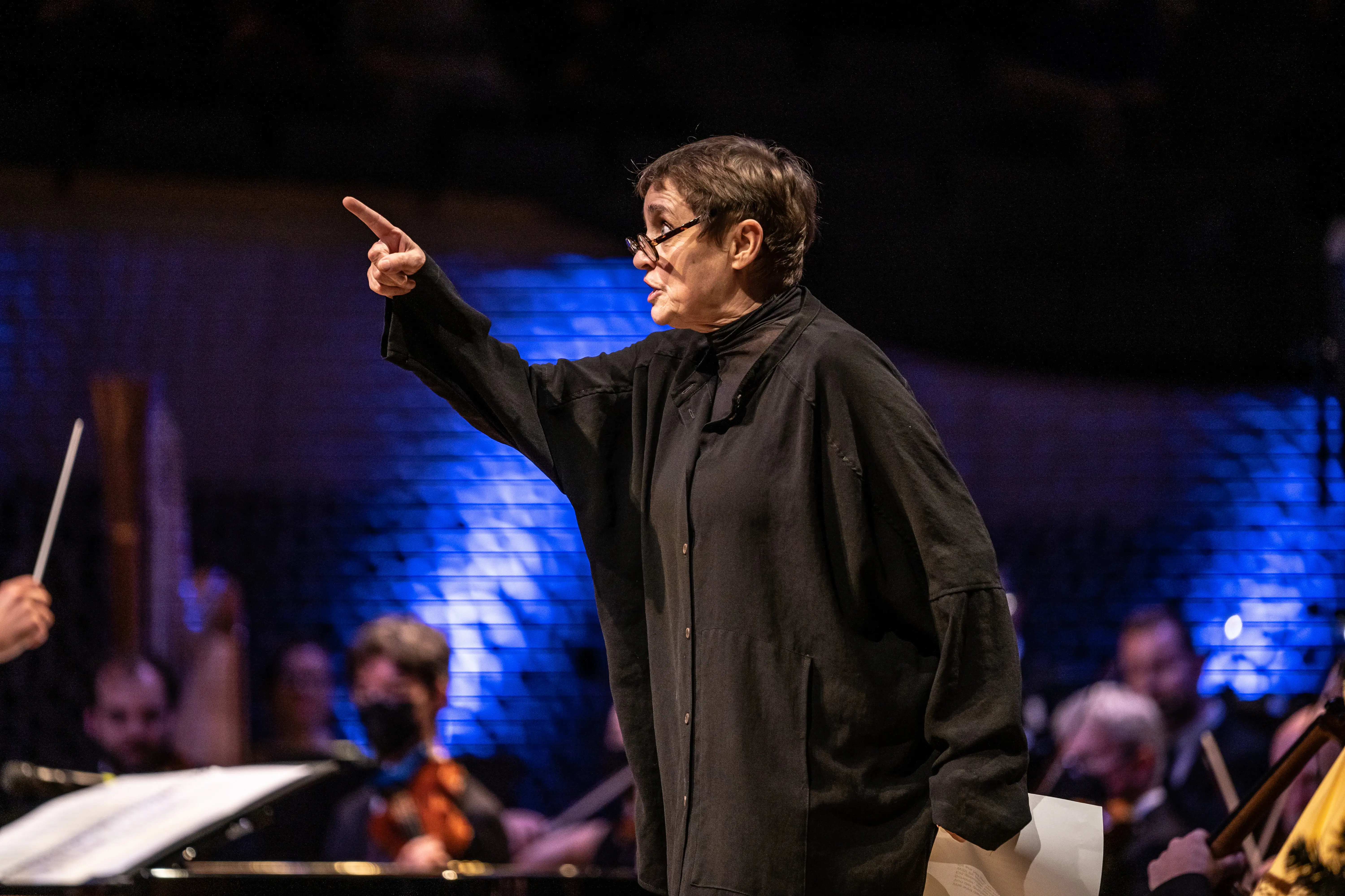 Katharina Thalbach Une femme portant des lunettes pointant du doigt.