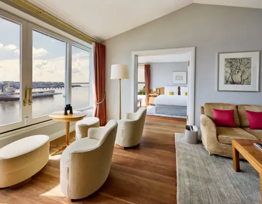 Chambre avec vue sur l'eau et un lit au premier plan.
